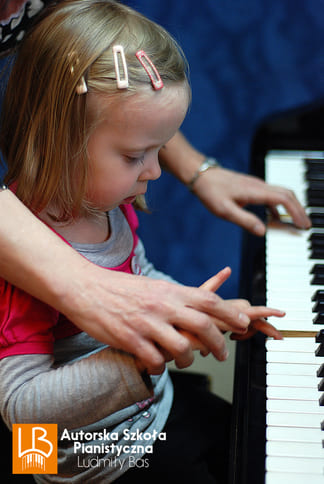 dziewczynka gra i przyciska klawisze pianina